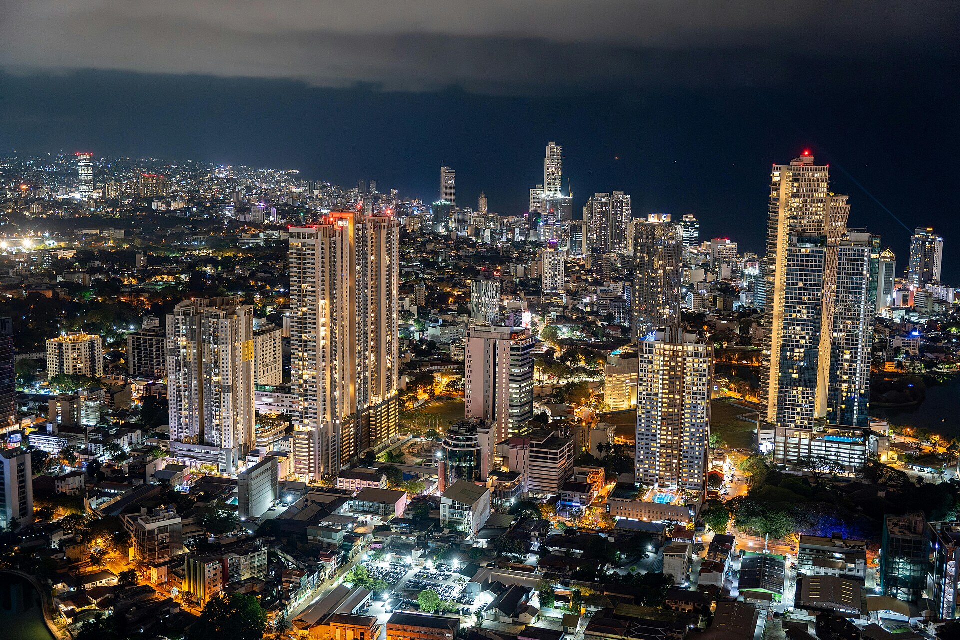 Colombo's city skyline glowing at night above the Indian Ocean, seen from a rooftop bar - the view that makes the city's sky bars worth it