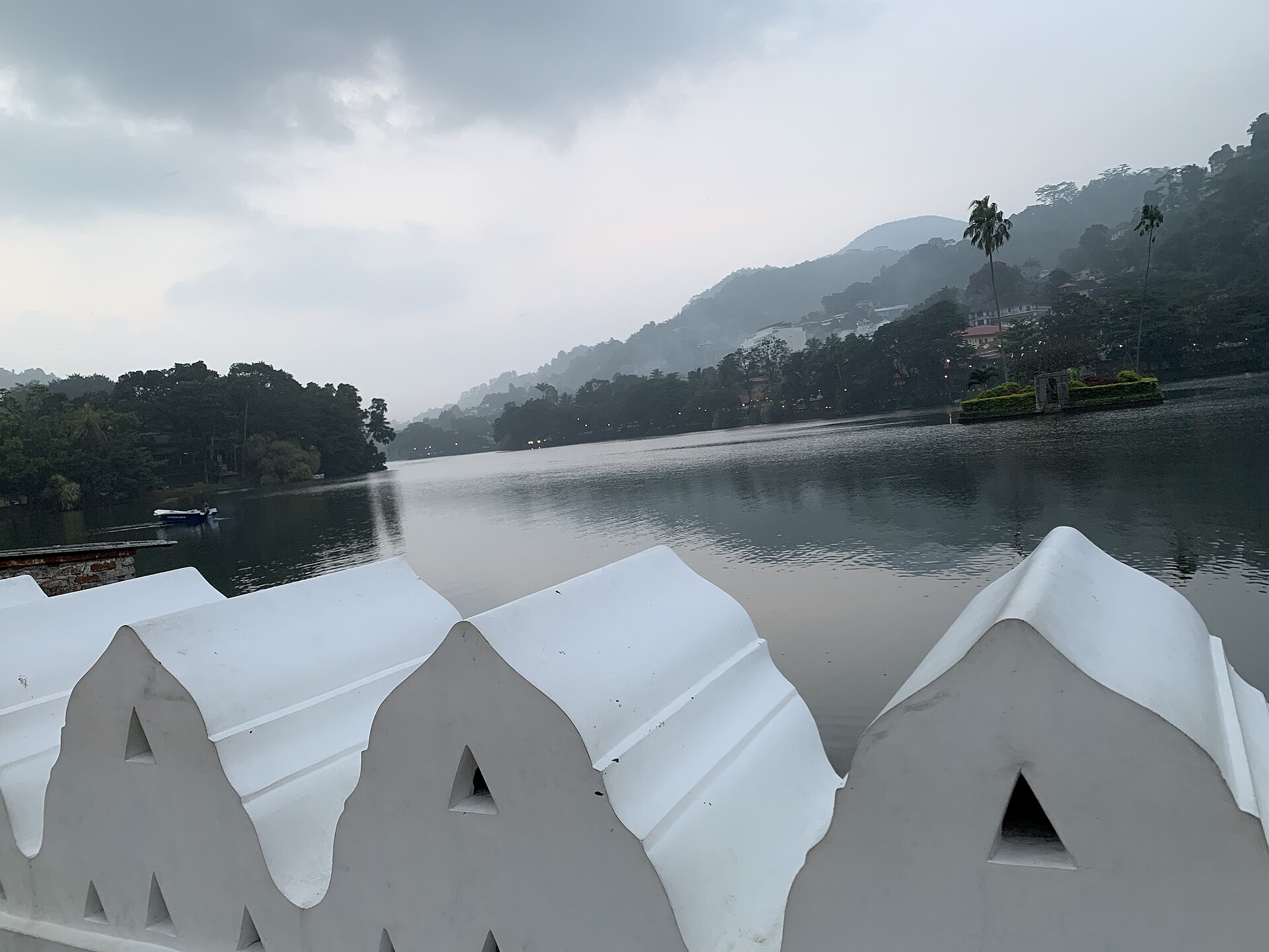 Kandy Lake at dawn, with the wooded island at its centre and the hills of the central highlands behind