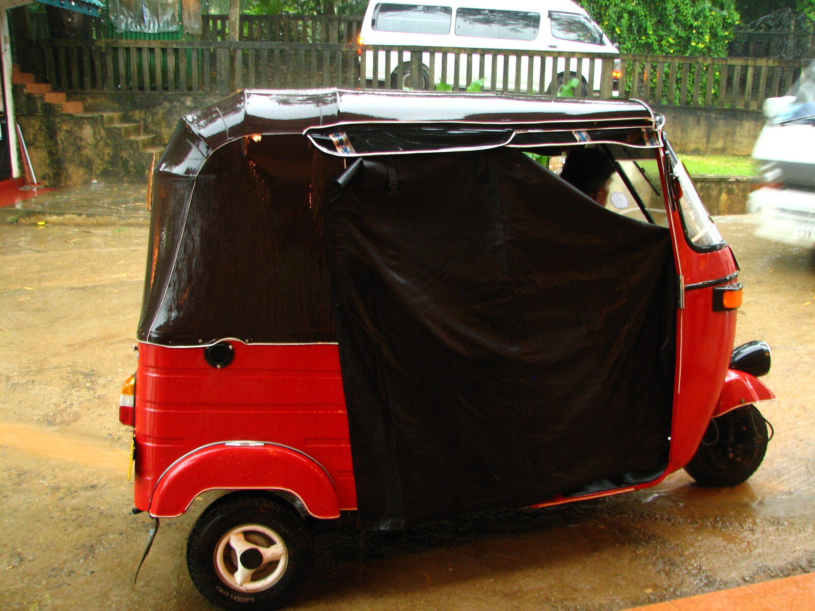 A tuk-tuk covered with a rain sheet in Sri Lanka — monsoon showers are part of the deal, so pack rain gear
